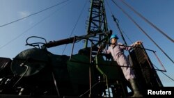 A technician of Cuba's state-run CUPET monopoly works on an oil pump in Havana, July 11, 2014. 