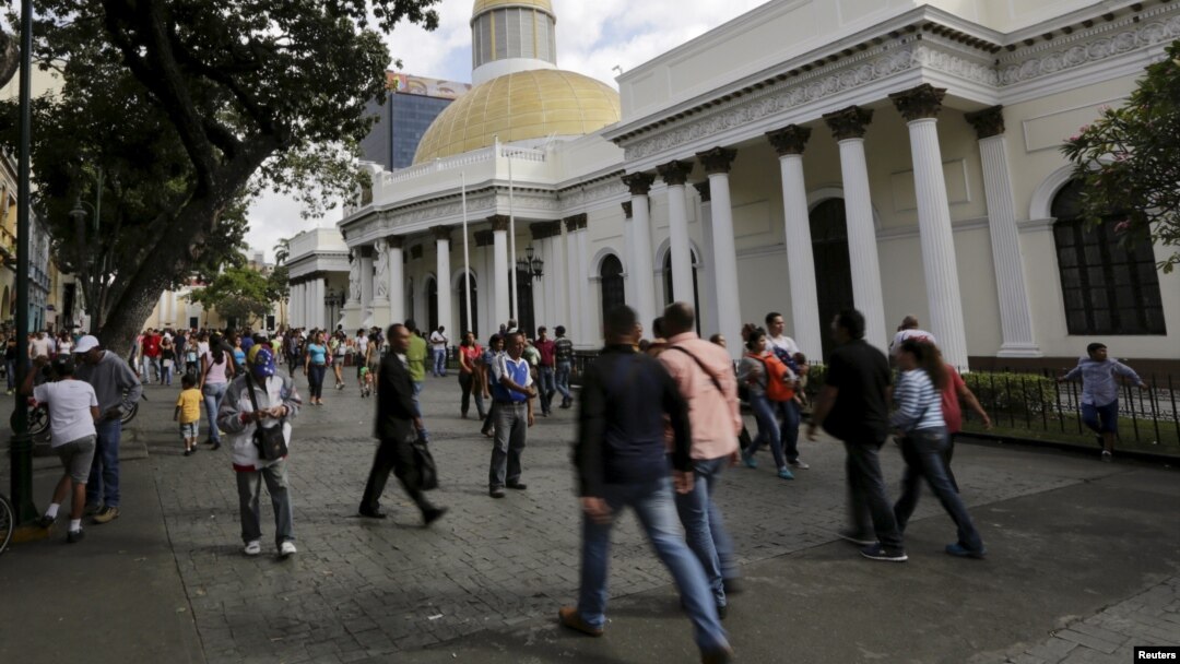 FILE - People walk past the National Assembly building in Caracas, Venezuela, Dec. 22, 2015.