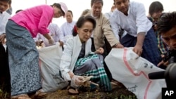 Leader of National League for Democracy party (NLD) Aung San Suu Kyi, front center, picks up garbage during a clean-up drive in Kawhmu, Myanmar, Dec. 13, 2015.