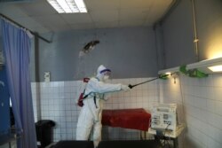 A health worker, wearing a protective suit and face mask, disinfects a room of a hospital after a case of Ebola was confirmed in Abidjan, Ivory Coast, August 16, 2021.