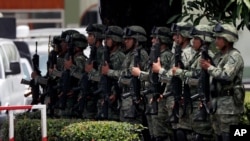 Mexican soldiers present arms as the country's Minister of Defense drives by, in Tapachula, Mexico, June 11, 2019. 
