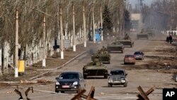 Konvoi kendaraan lapis baja kelompok separatis yang didukung Rusia di Vuhlehirsk, dekat Debaltseve, Ukraina timur (22/2). (AP/Vadim Ghirda)