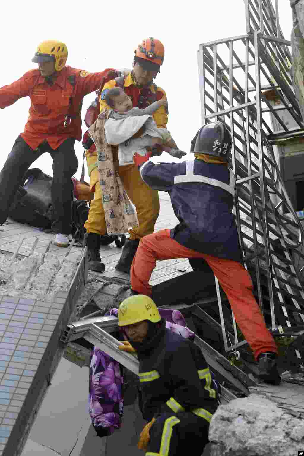 A child is carried from a damaged building. 