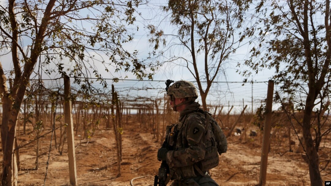 Seorang tentara AS tampak berjalan melalui kebun buah-buahan dalam patroli di salah satu desa di wilayah barat Irak. (Foto: AP/Susannah George)