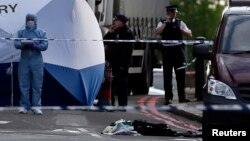 Petugas forensik dari kepolisian London tengah memeriksa lokasi kejadian dimana seorang pria tewas di Woolwich, London (22/5).