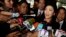 Ousted former Prime Minister Yingluck Shinawatra talks to reporters as she arrives at Parliament before the National Legislative Assembly meeting in Bangkok, Jan. 9, 2015.