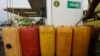 FILE - A man fills containers with diesel at a petrol station in Abuja, Nigeria, May 26, 2015. The new government of President Muhammadu Buhari said it would get country’s four refineries back up and running.