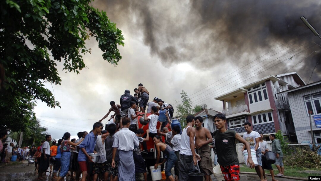 Warga di negara bagian Rakhine mengambil air dari truk pemadam kebakaran untuk memadamkan kebakaran rumahnya dalam bentrokan antara ummat Budha dan muslim Rohingya (10/6). 