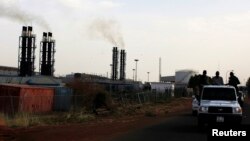 FILE - A vehicle with Sudan People's Liberation Army (SPLA) soldiers travels past the Paloch oil field facility in Paloch, Upper Nile state, South Sudan, March 2, 2014.