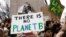 FILE - Students hold placards during a demonstration against climate change at Columbus Circle in New York, March 15, 2019. 