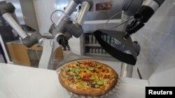 Robot pizzaiolo menyiapkan pizza di depan mata pelanggan di ruang pamer startup makanan Prancis, sebagai ilustrasi. (Foto: Reuters)