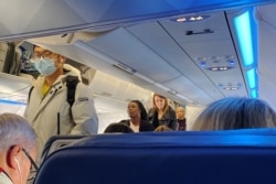 A passenger wearing a mask boards a flight after cases of the coronavirus have been confirmed in the U.S., in Boston, Massachusetts, Jan. 24, 2020.