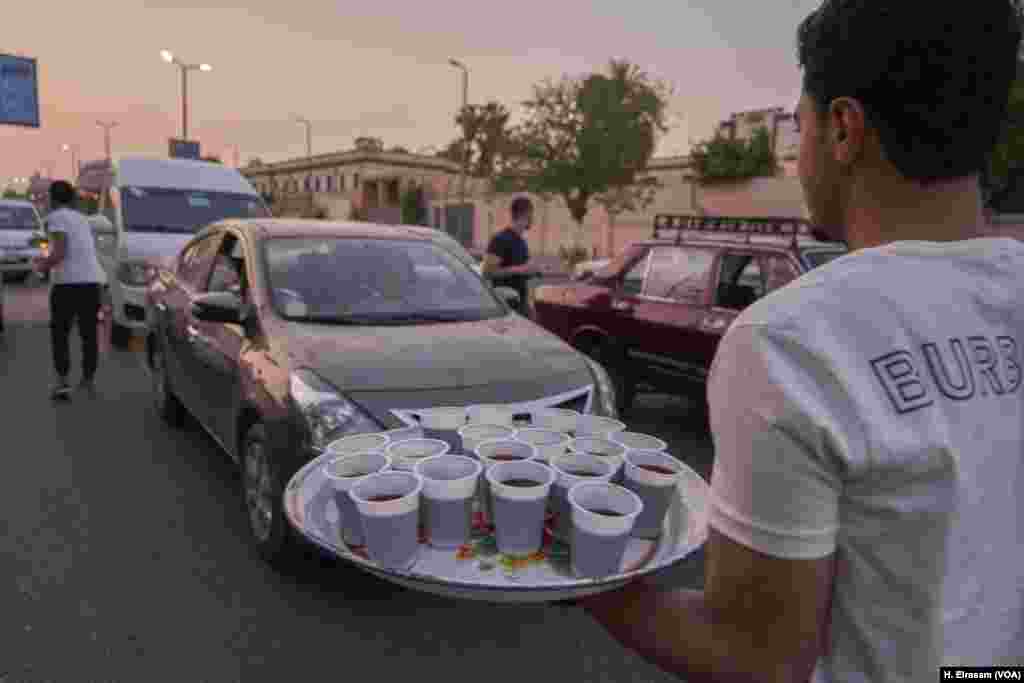 Young Egyptians distribute juice and dates to passersby and drivers in their cars at the time of Iftar.