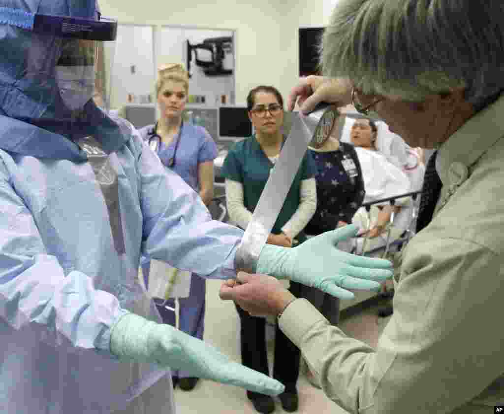 Para perawat mendemonstrasikan prosedur perlindungan Ebola yang benar kepada dokter dan perawat dalam pelatihan di Rush University Medical Center, Chicago, AS (16/10). (AP/Charles Rex Arbogast)