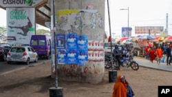 FILE - Election posters displayed on a pillar, in Accra, Dec. 4, 2024, ahead of the presidential election.