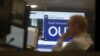 A traders works as EU Referendum results come in on a giant screen behind, in London, Britain, June 24, 2016.