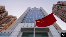 FILE - A Chinese national flag flutters outside China's liaison office building in Hong Kong, Jan. 6, 2020.