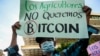 Un homme tient une banderole sur laquelle est écrit "Les agriculteurs ne veulent pas de bitcoin" lors d'une manifestation contre la circulation du bitcoin à San Salvador, le 7 septembre 2021.