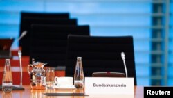 FILE - The empty chair of German Chancellor Angela Merkel is seen as she participates in the weekly cabinet meeting by video, since she has gone into home quarantine because of the coronavirus disease, in Berlin, Germany, March 23, 2020.