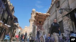 FILE - An Egyptian traditional "Baladi" flatbread vendor rides his bicycle outside a bakery, in the Old Cairo district of Cairo, Egypt, Saturday, Feb. 11, 2023. 