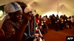 Margaret Achieng, 80 ans, tient son chapelet au nom de sa fille Doreen, à Nairobi le 7 août 2018.