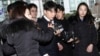 Seungri, center, member of a popular K-pop boy band Big Bang, arrives at the Seoul Metropolitan Police Agency in Seoul, South Korea, March 14, 2019.