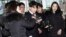 Seungri, center, member of a popular K-pop boy band Big Bang, arrives at the Seoul Metropolitan Police Agency in Seoul, South Korea, March 14, 2019.