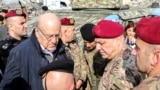 Lebanon's caretaker Prime Minister Najib Mikati (2nd-L) and Lebanese army commander, General Joseph Aoun (2nd-R), visit the southern Lebanese village of Khiam on Dec. 23, 2024, after the withdrawal of Israeli forces from the area. 