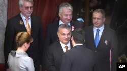 Hungarian Prime Minister Viktor Orban (C) congratulates re-elected Hungarian President Janos Ader (Front) in the presence of Ader's wife, Anita Herczegh (L), Deputy PM in charge of national politics Zsolt Semjen (Back C), and Fidesz faction leader Lajos Kosa (R) during the plenary session of the parliament in Budapest, Hungary, March 13, 2017. 