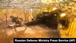 In this photo taken from a video released by the Russian Defense Ministry press service on Sept. 26, 2024, a Russian serviceman fires toward Ukrainian positions at an undisclosed location in Ukraine. (Russian Defense Ministry Press Service via AP)