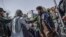 Anggota Taliban menghentikan protes perempuan untuk hak-hak perempuan di Kabul, 21 Oktober 2021. Taliban dengan keras menindak liputan media tentang protes hak-hak perempuan di Kabul pada 21 Oktober pagi, memukuli beberapa wartawan. (BULENT KILIC / AFP)