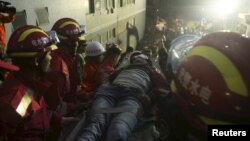 The 19-year-old survivor (C) is carried on a stretcher after being pulled out by rescuers more than 60 hours after a landslide hit an industrial park on Sunday, in Shenzhen, Guangdong province, China, Dec. 23, 2015. 