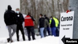 FILE - People queue at a COVID-19 testing center after controls were tightened due to the coronavirus outbreak, at the Czech-German border in Folmava, Czech Republic, Jan. 25, 2021. 