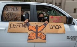 An immigrant family joins members of Coalition for Humane Immigrant Rights of Los Angeles, CHIRLA, on a vehicle caravan rally to support the Deferred Action for Childhood Arrivals Program (DACA), around MacArthur Park in Los Angeles, June 18, 2020.