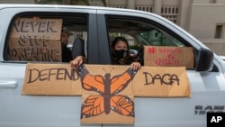 FILE - An immigrant family joins members of Coalition for Humane Immigrant Rights of Los Angeles on a vehicle caravan rally to support the Deferred Action for Childhood Arrivals Program (DACA), around MacArthur Park in Los Angeles, June 18, 2020. 