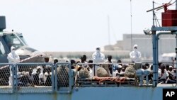 FILE - Migrants are seen aboard the French NGO SOS Mediterranee Aquarius ship Orione as it arrives at the eastern port of Valencia, Spain, Jun. 17, 2018.