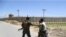 An Afghan National Army (ANA) soldier salutes locals riding on a motorbike outside Bagram Air Base, after all US and NATO troops left, some 70 kilometers north of Kabul on July 2, 2021. 