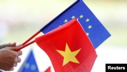FILE- European Union and Vietnamese flags are seen at the signing ceremony of EU-Vietnam Free Trade Agreement at the government office in Hanoi, Vietnam, June 30, 2019.