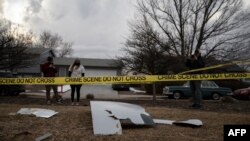 Warga mengabadikan serpihan-serpihan mesin pesawat United Airlines yang jatuh di kawasan permukiman Broomfield di luar Kota Denver, Colorado, 20 Februari 2021. 