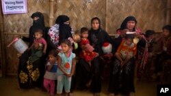 Para perempuan Muslim Rohingya membawa anak-anaknya untuk menerima tambahan gizi di kamp pengungsi Balukhali, dekat Cox's Bazar, Bangladesh (23/1). 