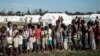 Anak-anak mengantre untuk menerima distribusi makanan dari supermarket lokal di pusat evakuasi di Dondo, sekitar 35 km sebelah utara dari Beira, Mozambik, pada 27 Maret 2019. (Foto: Yasuyoshi CHIBA/AFP)