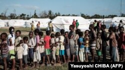 Anak-anak mengantre untuk menerima distribusi makanan dari supermarket lokal di pusat evakuasi di Dondo, sekitar 35 km sebelah utara dari Beira, Mozambik, pada 27 Maret 2019. (Foto: Yasuyoshi CHIBA/AFP)