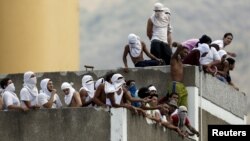 Presos vigilan desde la azotea de una comisaría de la PNB en Catia, Caracas.