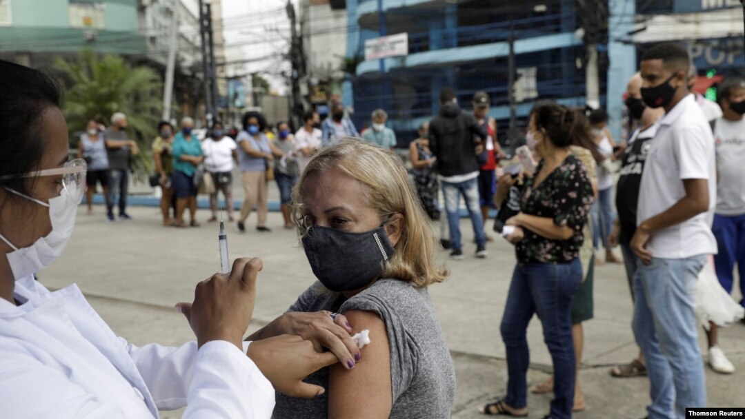 Un trabajador de la salud administra una vacuna a una mujer en Río de Janeiro, Brasil en abril de 2021.