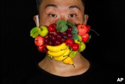 Edmond Kok, a Hong Kong theater costume designer and actor, wears a face mask designed to look like fruits in Hong Kong Aug. 6, 2020.