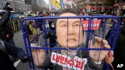 Protesters carry a caricature depicting an imprisoned South Korean President Yoon Suk Yeol as they march to the presidential office after a rally demanding his impeachment in Seoul, South Korea, Dec. 12, 2024. 