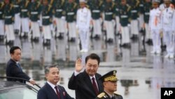 Presiden Korea Selatan Yoon Suk Yeol melambaikan tangan ke arah pengunjung dalam parade untuk memperingati Hari Angkatan Bersenjata Korea Selatan ke-75 di Seongnam, Seoul, Korea Selatan, Selasa, 26 September 2023. (Foto: Kim Hong-ji/Pool via AP)