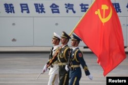 FILE - Soldiers of People's Liberation Army march in formation with a Chinese Communist Party flag during a rehearsal before a military parade marking the 70th founding anniversary of People's Republic of China, in Beijing, China, Oct. 1, 2019.