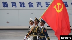 FILE - Soldiers of People's Liberation Army march in formation with a Chinese Communist Party flag during a rehearsal before a military parade marking the 70th founding anniversary of People's Republic of China, in Beijing, China, Oct. 1, 2019.