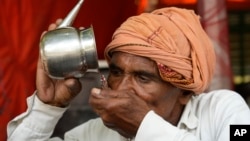 A man drinks water as severe heat grips Lucknow, India, on May 18, 2024.